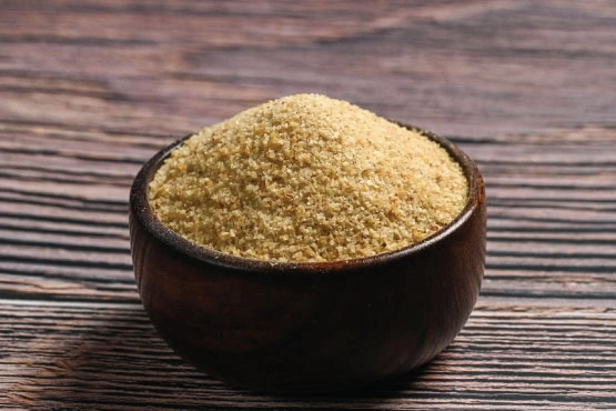 A bowl of white potato granules on a wooden table