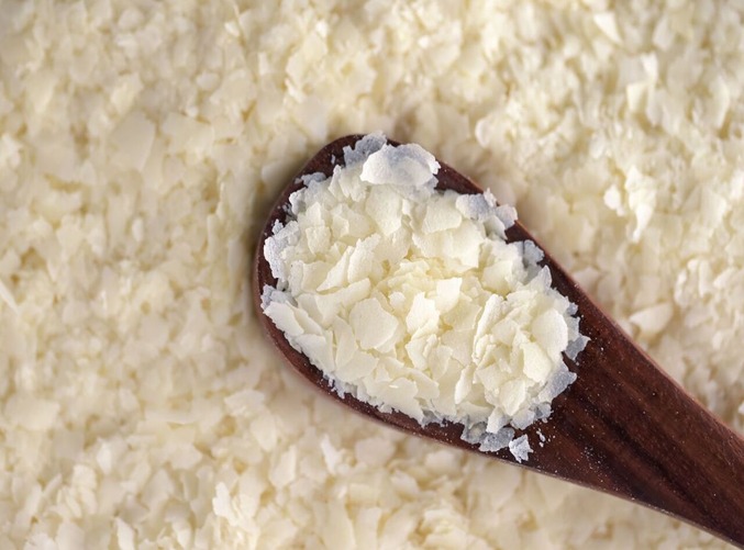  A spoonful of potato flakes on a white background .